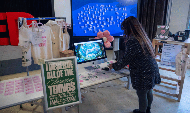 A table and a screen showing a variety of Visual Arts projects, from Portfolio Review Day 25 at IED Barcelona